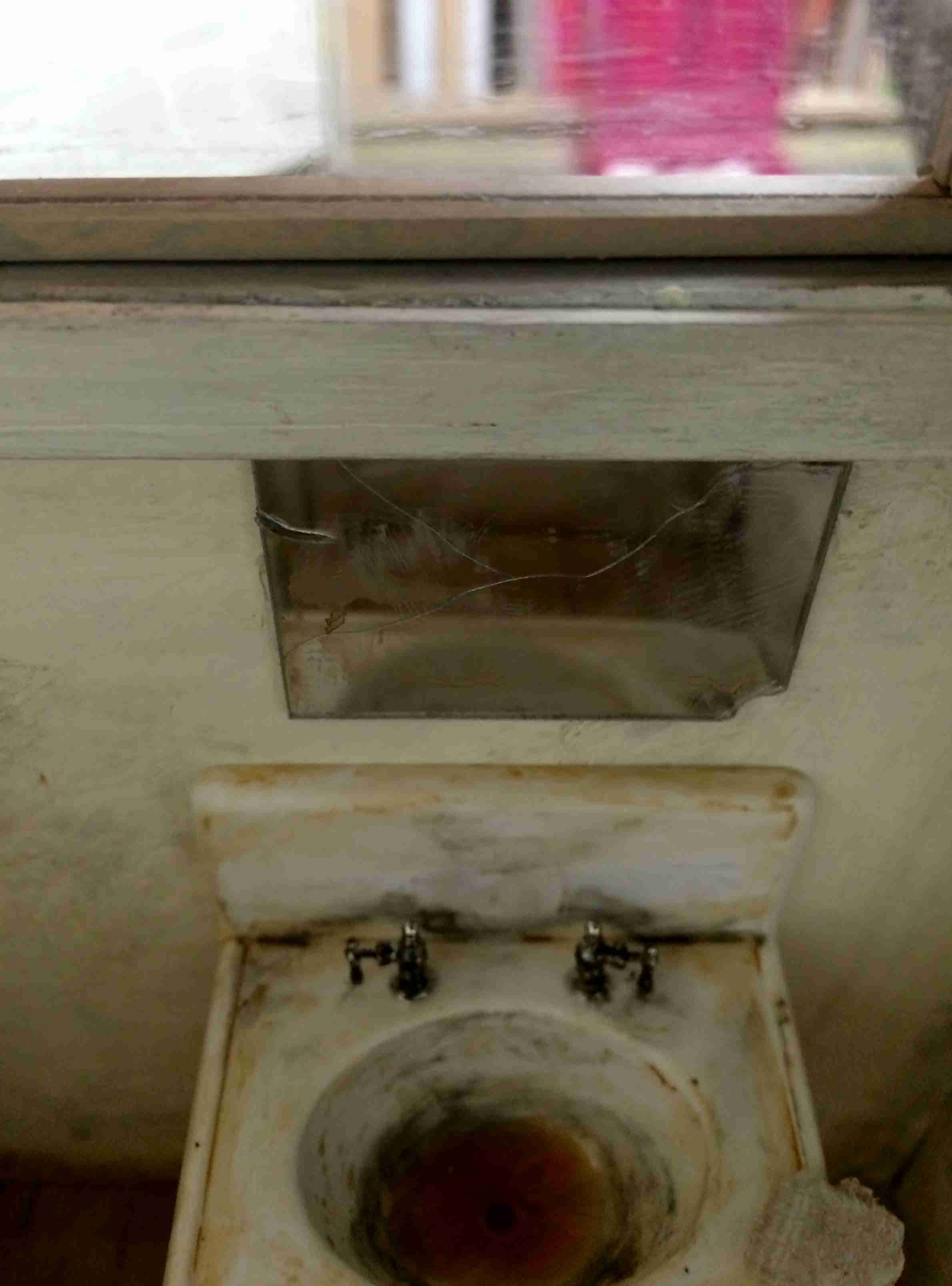 Dirty sink and cracked mirror